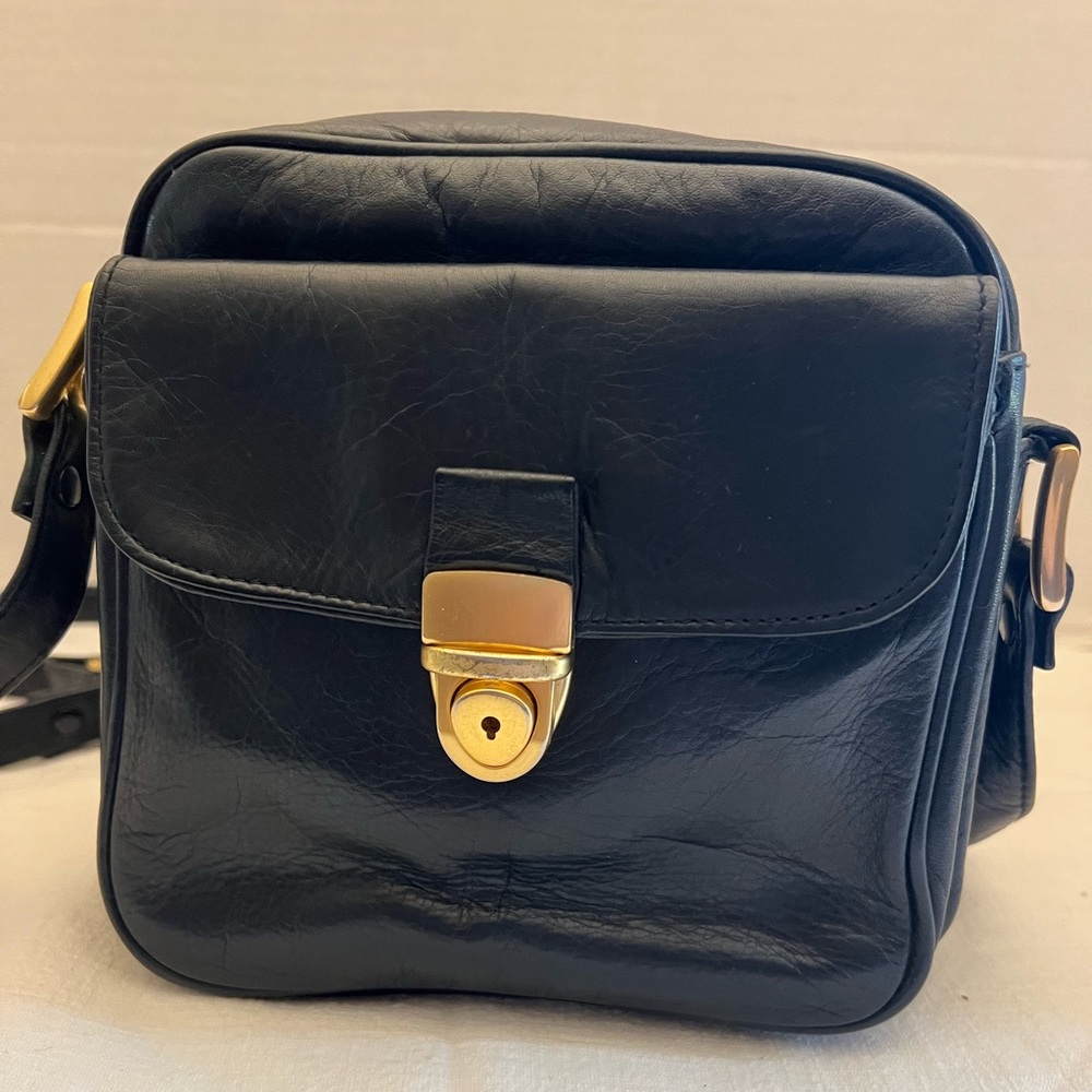Perlina black crossbody handbag with adjustable strap.